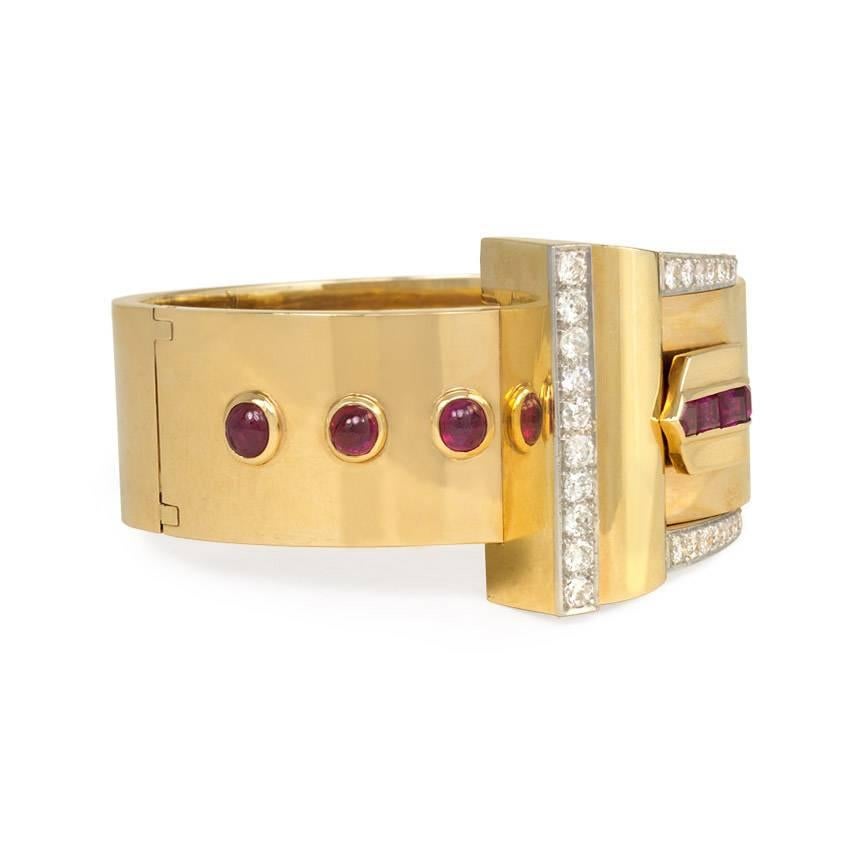 A Retro gold, ruby and diamond cuff bracelet with a buckled motif, in 14k and platinum.

Inner circumference approximately 6 3/8 inches