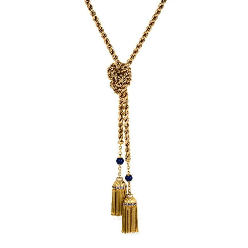 A long gold ropetwist lariat necklace accented with lapis beads on both ends and terminating in tassels suspending from fluted caps set with diamonds and sapphires, in 18k.  Atw 1.00 diamonds