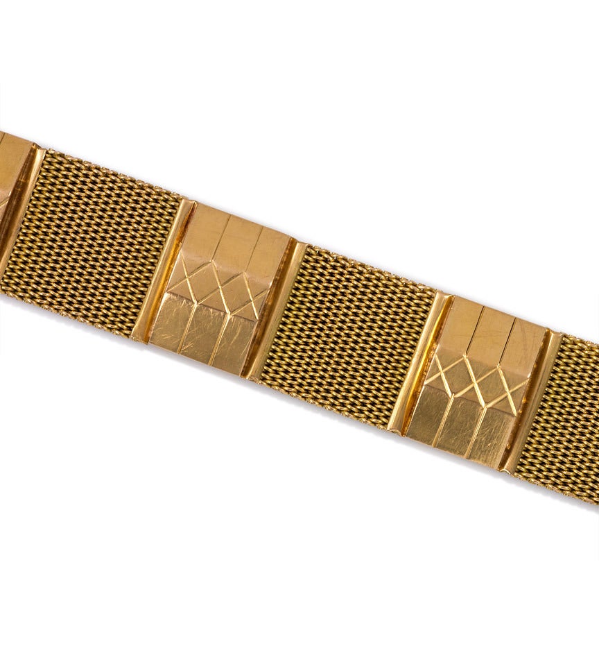 A Retro gold bracelet of alternating woven mesh and etched trapezoidal links, in 18k.