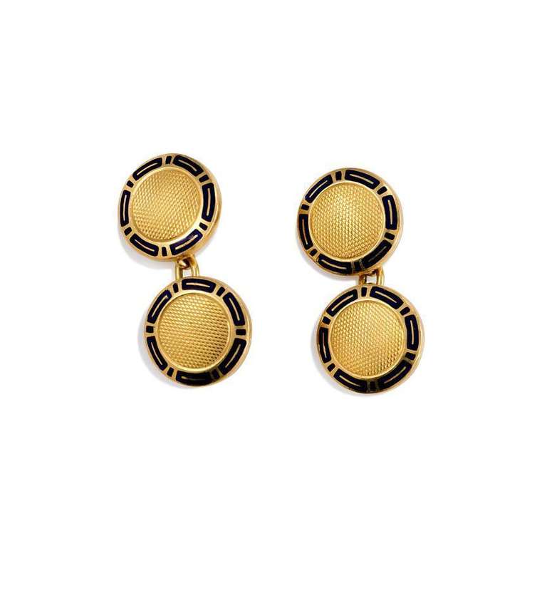 A pair of double-sided round gold cufflinks with black enamel borders and textured centers, in 18k. Bulgari.