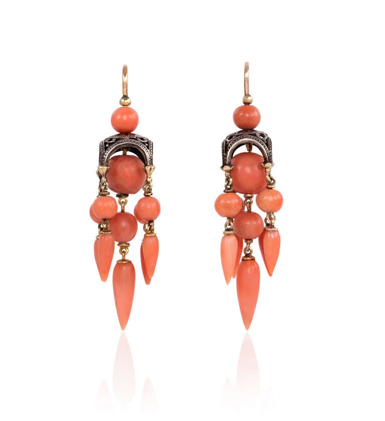 A pair of antique gold earrings in the Moorish style, comprised of pierced arabesque cupolas suspending five beaded coral pendants terminating in teardrops, in 18k. France.