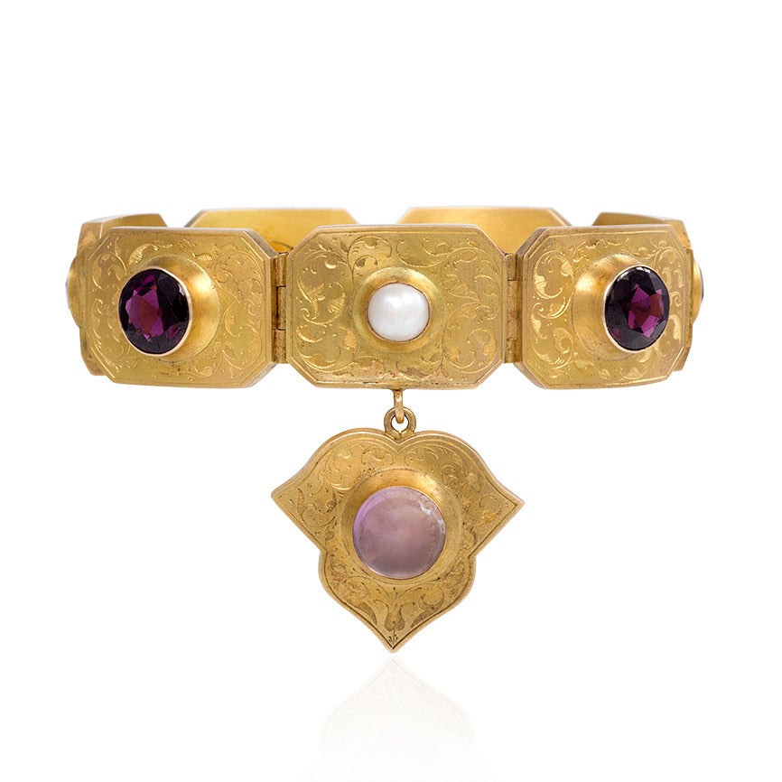 An antique Victorian period gold and multi-gemstone plaque bracelet with charm pendant, in 15k.  England.

The gold plaque links are beautifully decorated with delicate foliate engraving and feature a colorful array of set amethyst, citrine,