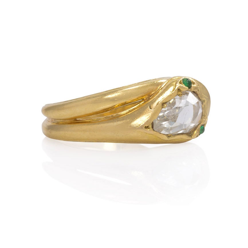 An antique gold bypass ring in the form of a snake with a pear-shaped diamond set head and emerald eyes, in 18k.  Sorley, England.  French import mark.