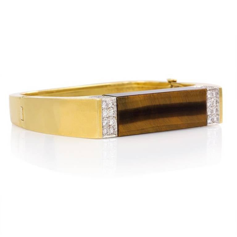 A bracelet of geometric design, inset with a rectangular tiger eye, flanked by pavé diamonds in 18K gold. Italy.