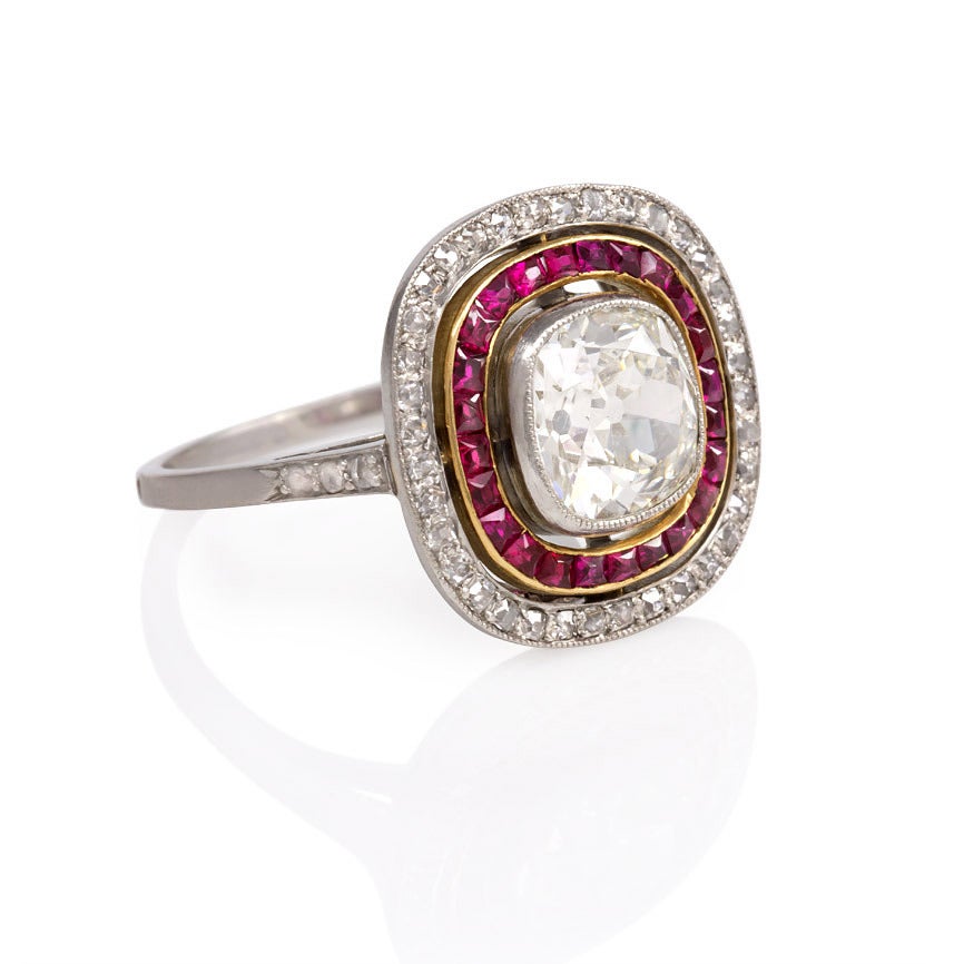An Art Deco ring comprised of two concentric rows of rubies and diamonds surrounding an old cushion cut diamond of approx. 1.46 ct., in platinum and 18k gold. France.