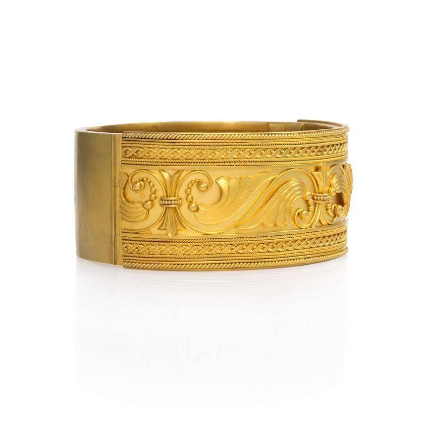 An antique gold cuff bracelet with an acanthus motif and applied bead and wire work, in 15k. England.  Inner circumference: 6.25