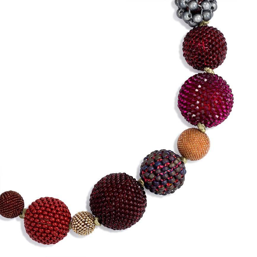 A glass, crystal, mother-of-pearl, and resin bead necklace comprising 23 hand beaded spheres of multiple sizes in red, amber and grey tones, completed by an 18k gold clasp.  Axel Russmeyer, Germany.  Custom orders accepted.  Largest bead 28mm,