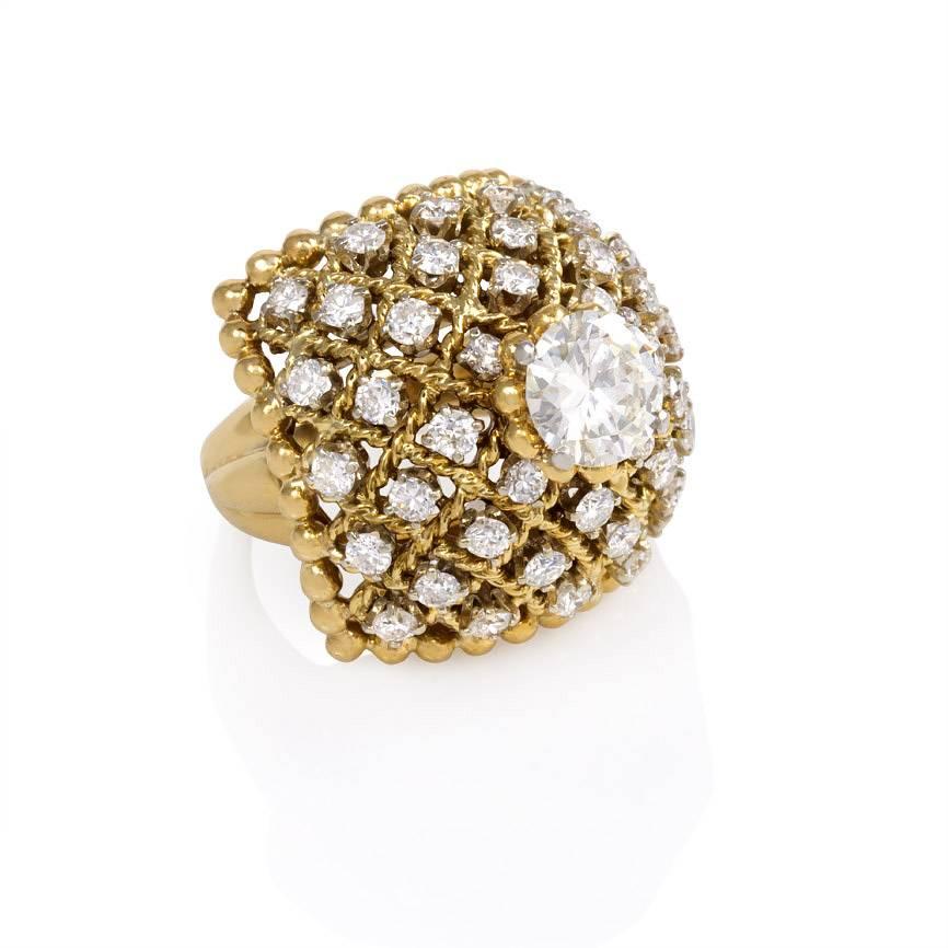 A cushion shaped cocktail ring of rope twist gold openwork in a caged motif, set with a central solitaire diamond (approx. 1.59 ct., I-J, SI2) and accented with approx. 1.60 ct. tw. diamonds, in 18k and platinum. Van Cleef & Arpels, New York,
