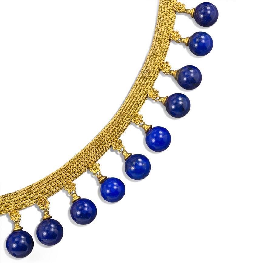 An antique woven gold necklace in the Etruscan style with graduated lapis bead fringe suspending from florette bales, in 18k.