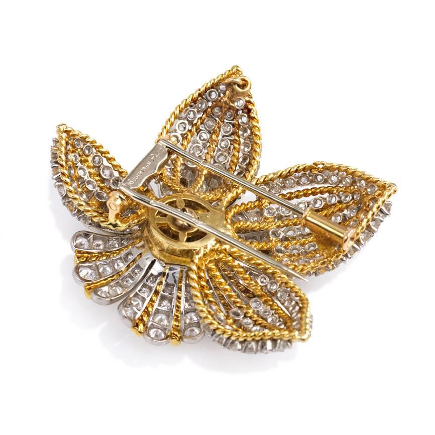 A Retro gold and diamond clip brooch in the form of a flower, set with approximately 8.29 cts. tw. diamonds, in 18K and platinum. Boucheron, Paris.