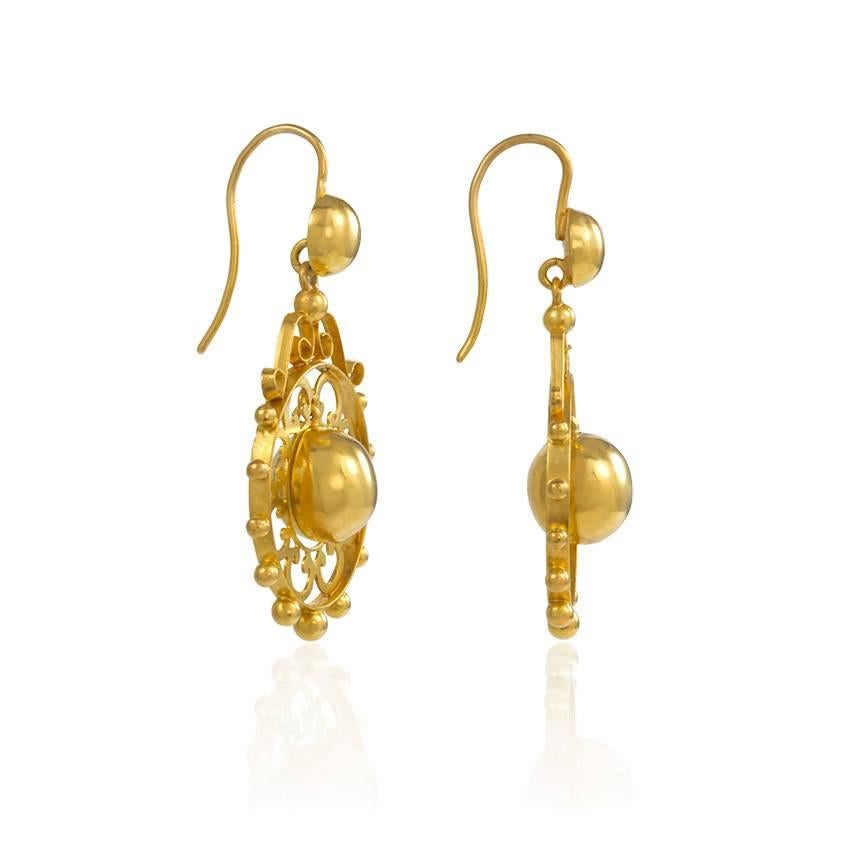 A pair of antique gold openwork earrings with articulated bead centers and decorated with scrollwork, in 15k.

Measures approximately 3.8 cm in length from top of wire