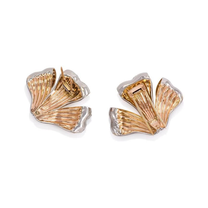 A pair of Retro rose gold and diamond clip brooches in the form of curling foliate petals. The clips are set with approx. 3.00 ct. tw. rose cut and single cut diamonds in 18K and platinum. Portugal.