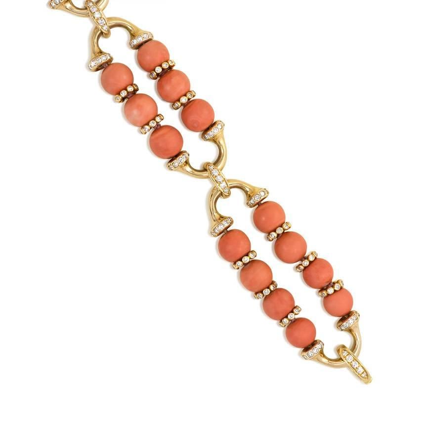 A gold, coral, and diamond bracelet comprised of three oblong sections of coral beads with diamond spacers, in 18K. Atw. 2.00 ct. single cut diamonds.