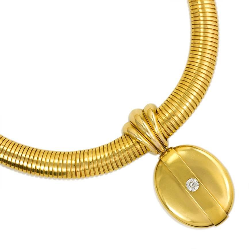 An antique gold gaspipe necklace with a central ribbed ornament suspending a detachable oval locket set with an old mine cut diamond, in 18k.

Necklace: 17" long
Locket: 1 5/8" long