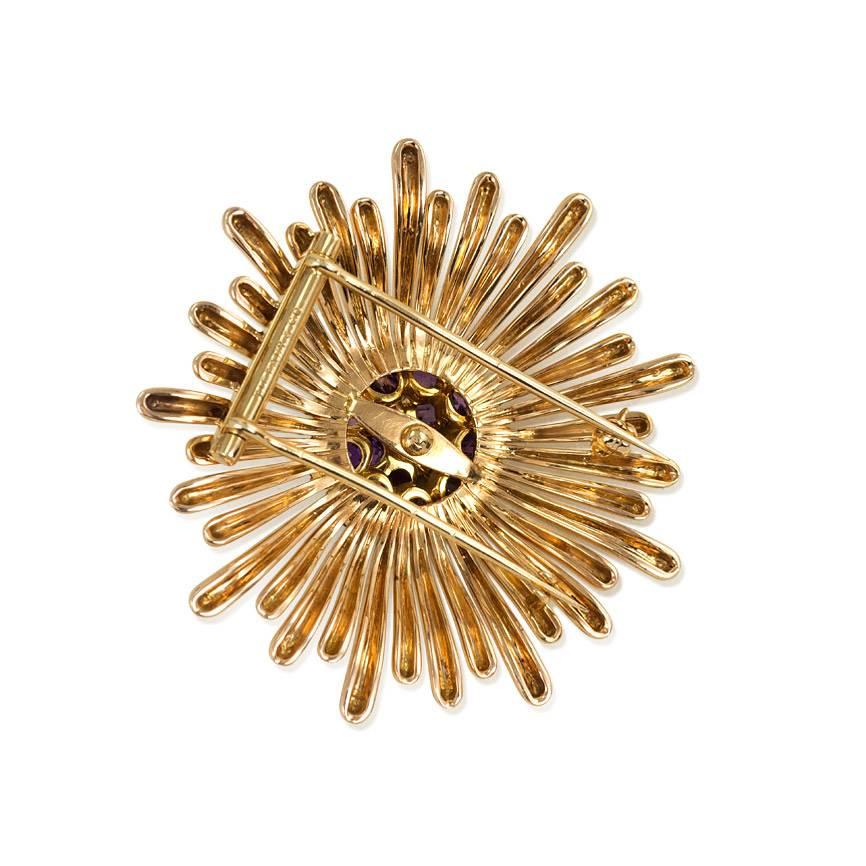 A Retro gold burst brooch of radiating design with a central amethyst and diamond cluster, in 14k. Tiffany & Co.