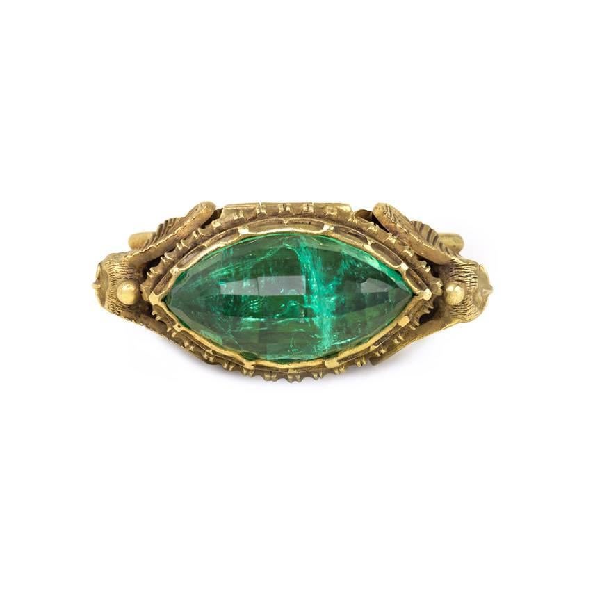 An antique Egyptian Revival poison ring, surmounted by a faceted lozenge-shaped emerald and flanked by stylized sphinxes, in 18k gold. Marcus & Co.  Pictured in "Rings - Jewelry of Power, Love and Loyalty" by Diana Scarisbrick, 2007,