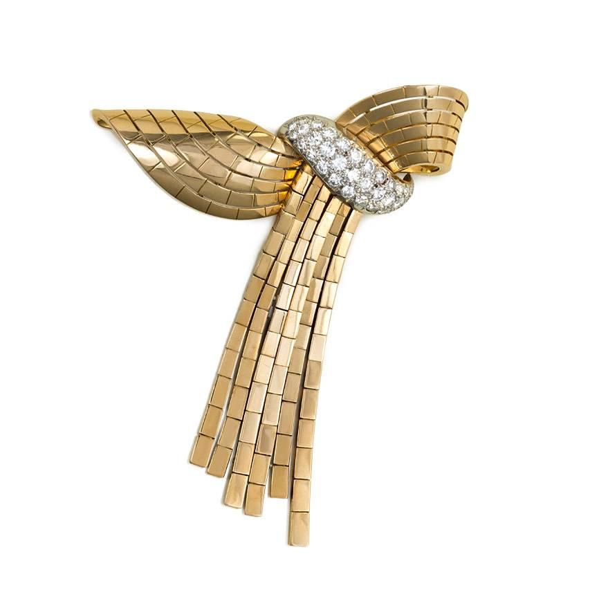 A Retro gold and diamond swag necklace with a detachable draped clip brooch of stylized ribbon design, in 18k and platinum. Garrard, London. French made.
Clip measures 3 1/4