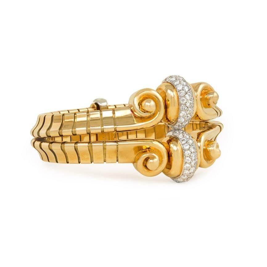 A Retro gold and diamond bracelet featuring a centerpiece of scroll motifs and curved pavé diamond elements, to a two-row modified tubular link bracelet, in 18k and platinum.  Mauboussin, Paris.