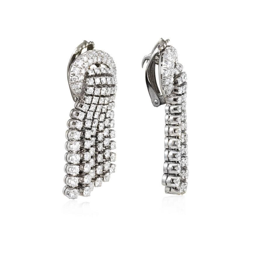 A pair of diamond tassel earrings, the graduated tassels of bias design and issuing from a stylized buckle, in platinum and 18K white gold.  Atw. 5.14 ct. diamonds.