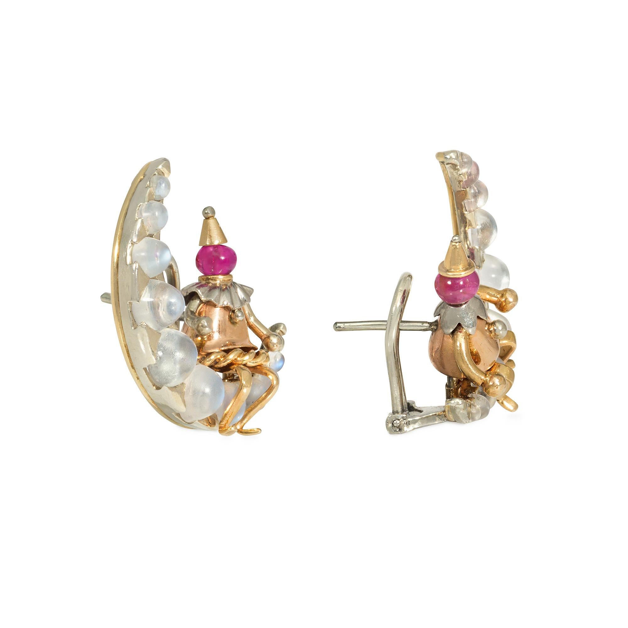Un par de pendientes de clip retro de oro tricolor en forma de hombre en la luna, diseñados como figuras de payaso pierrot con cabezas de cuentas de rubíes sentadas sobre una luna creciente engastada con piedras lunares graduadas, en 14k. Atribuido