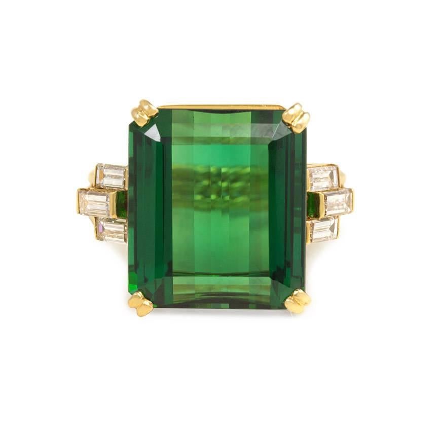 A gold and green tourmaline cocktail ring, the center emerald cut tourmaline set in an openwork gallery and flanked on both sides by three diamond baguettes, completed by a triple row band of ropetwist design, in 18k.  Mounted by Cartier. Tourmaline