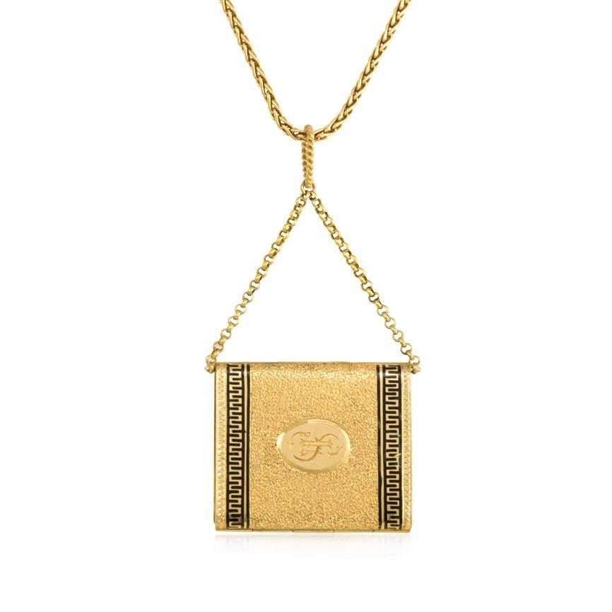 An antique gold book form locket pendant with stippled and engraved surface and black enamel decoration, which opens to reveal four double-sided picture frames, suspending from a woven gold chain, in 18k.

Chain: 18" long, pendant: 1 7/8"