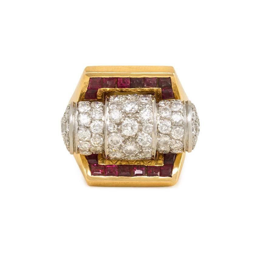 A Retro gold, diamond, and ruby architectural ring centering on a cylindrical pavé diamond scroll flanked by calibré rubies in a flared mount, with diamond-accented shoulders, in 18k and platinum.  France.  Atw. 2.50 ct. diamonds.

Top measures