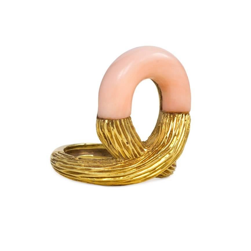A textured gold and angel skin coral ring of looping design, in 18k. Cartier #39704

Loop dimensions: 2.4 x 1.8cm