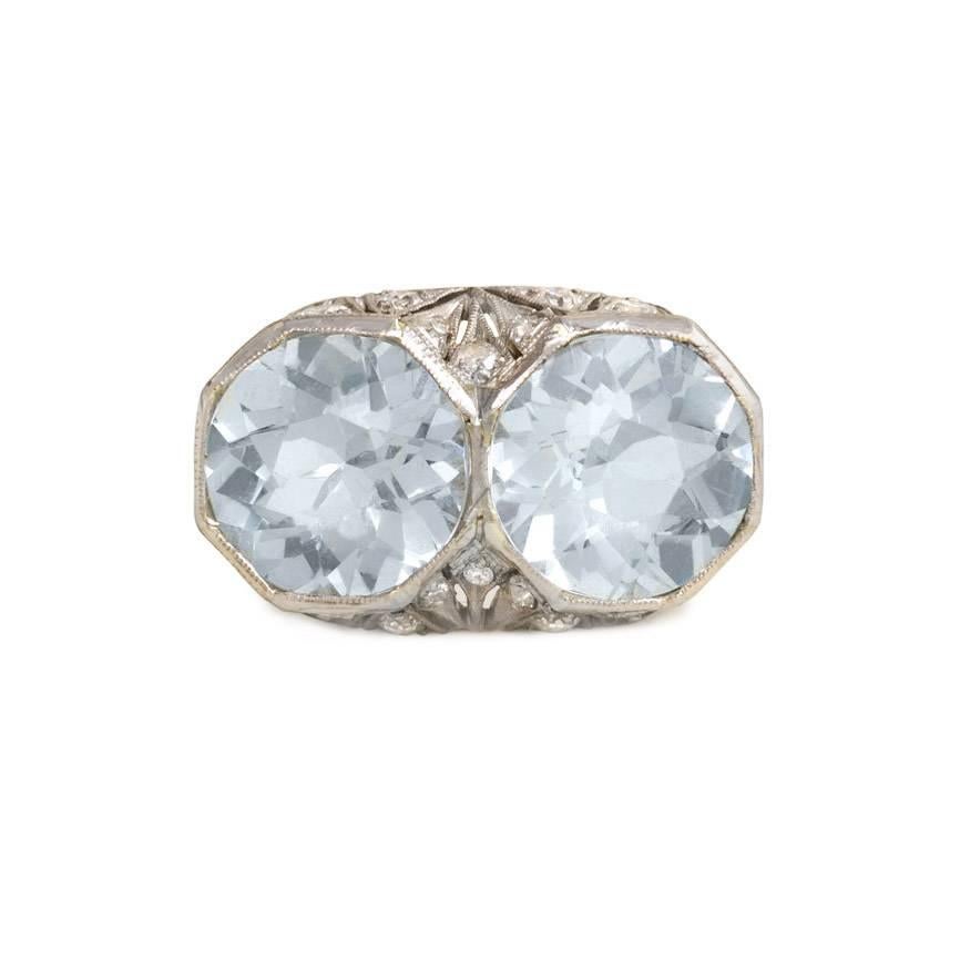An Art Deco two-stone aquamarine ring, in a pierced mounting set with diamonds, in platinum.  Atw aquamarines 2.12 cts. and 2.18 cts., respectively; atw diamonds 0.54 ct.

Top of ring measures approximately 8mm x 20mm
Current ring size: 5 1/2