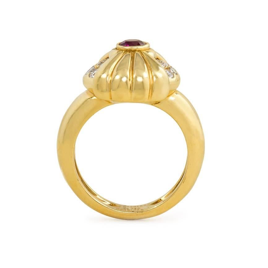 A versatile gold ring centering on a cushion-shaped element set with diamonds and overlaid with a gold and ruby fluted bow that rotates to hide the diamonds, in 18k. Boucheron, #B645.1139 3.

Top dimensions: 5/8