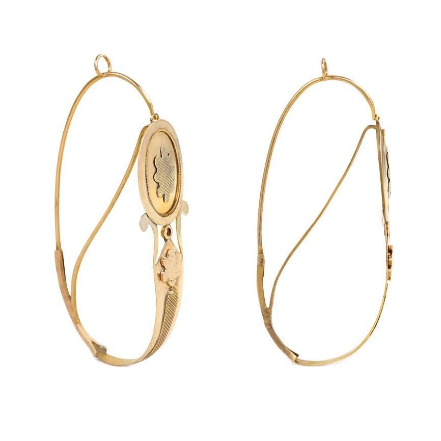 A pair of antique gold poissarde earrings of hoop design with textured floral plaques, in 18k. France