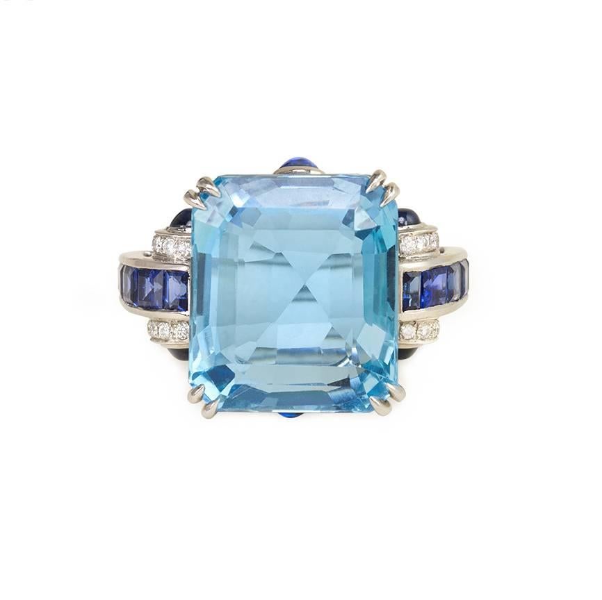 A Retro aquamarine cocktail ring in a sapphire and diamond mounting with cabochon sapphire terminals accenting the open gallery, in platinum.  Atw aquamarine 10.38 cts.

Top of ring measures approx. 9/16 x 7/8"