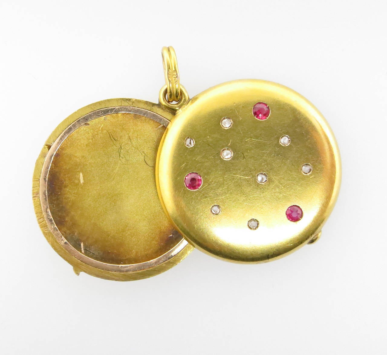 Art Nouveau 14kt. bloomed yellow gold slide locket circa 1900. The front of the locket is set with eight rose cut diamonds and three faceted natural rubies. Minor surface abrasion.