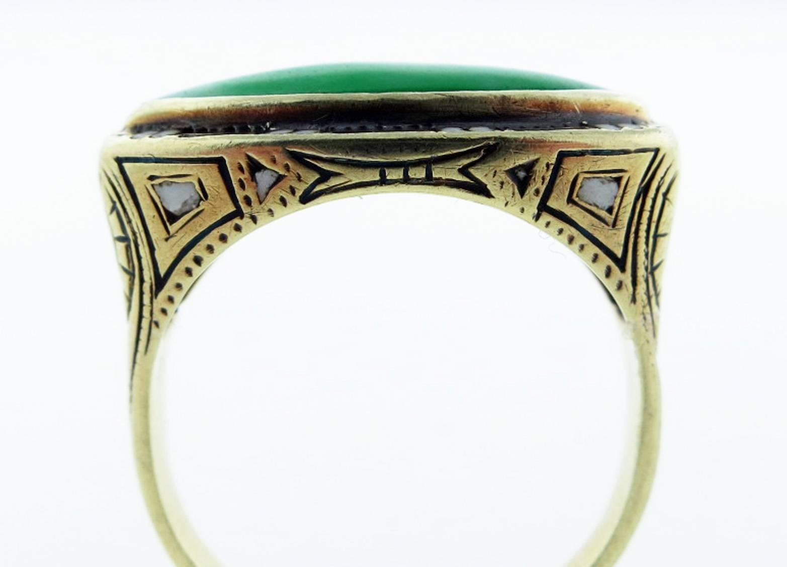 A fine Art Deco treasure in the Egyptian revival style circa 1925. The mounting is finely engraved and set with a marquise cut natural jade cabochon accented with black and white enamel. The ring is size 5 and can be sized.