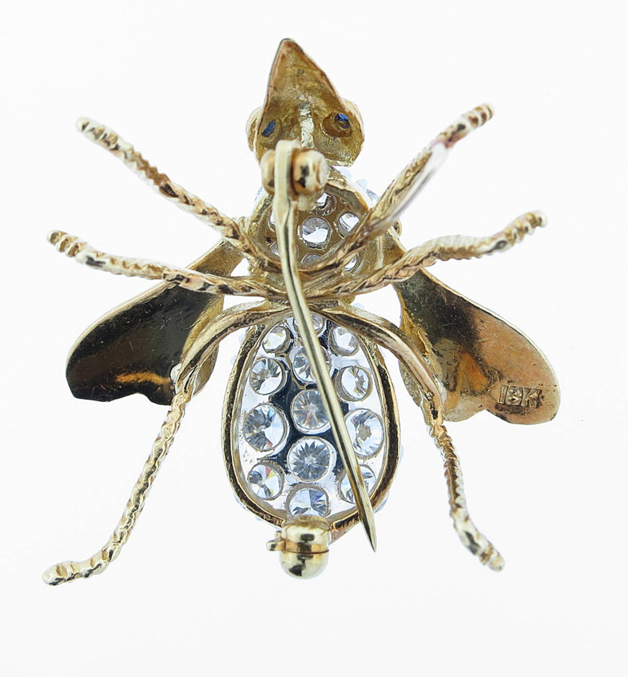18kt. yellow and white gold bee in a dimensional engraved mount on the front and back. The body of the bee is prong set in white gold with 20 round extremely fine round brilliant cut diamonds totaling approx. 2.5cts. with faceted sapphire eyes. The