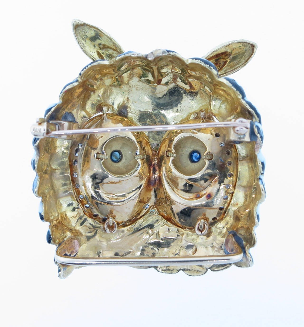 Very well executed  2 inch x 1.5 inch owl brooch. The face is in three color enamel and set with cabochon sapphire eyes, ten round faceted natural rubies and 28 round diamonds. The brooch weighs an impressive 51.2 gr.