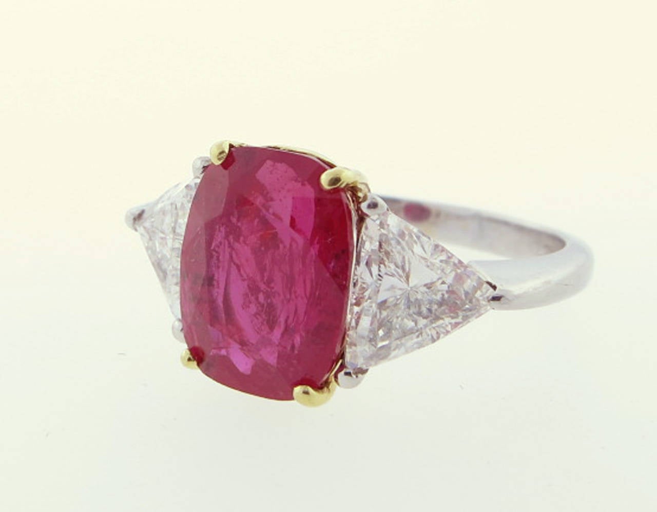 Handmade platinum and 18kt. yellow gold ruby and diamond ring.  GRS gemstone report  ruby weighing 5.7cts. measuring 11.4 x 8.7 x 5.59 mm.  Tajikistan origin. Each side is set with a triangular cut diamond each weighing approx 1.2cts. grading