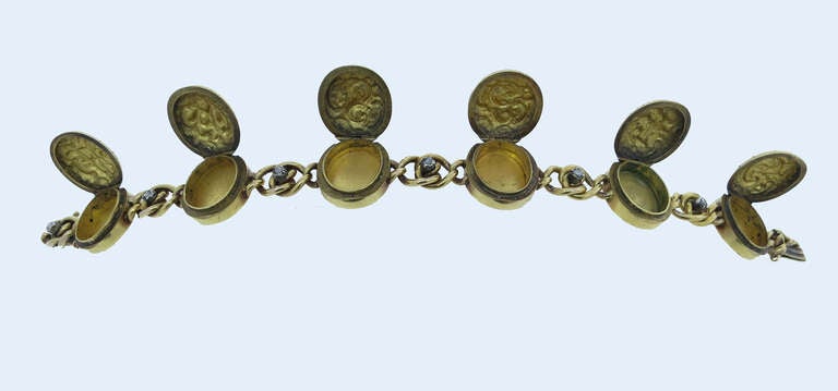 Sentimental and rare 14kt yellow gold repousse' locket bracelet. Each of the six initial engraved top lockets opens and are spaced by rose cut diamonds. The bracelet weighs 35.4gr. and measures 8