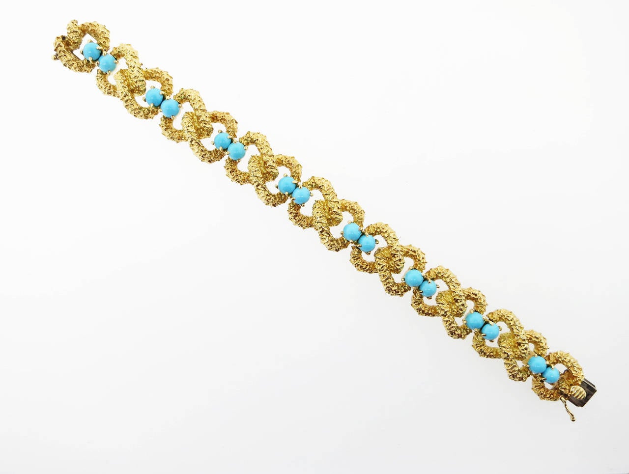 Bark finish 18kt. yellow gold link bracelet with turquoise. The bracelet is set with 16 natural robin egg blue turquoise cabachons each measuring approx 5mm. The bracelet measures 7 inches and weighs 59.6 gr. Circa 1960.