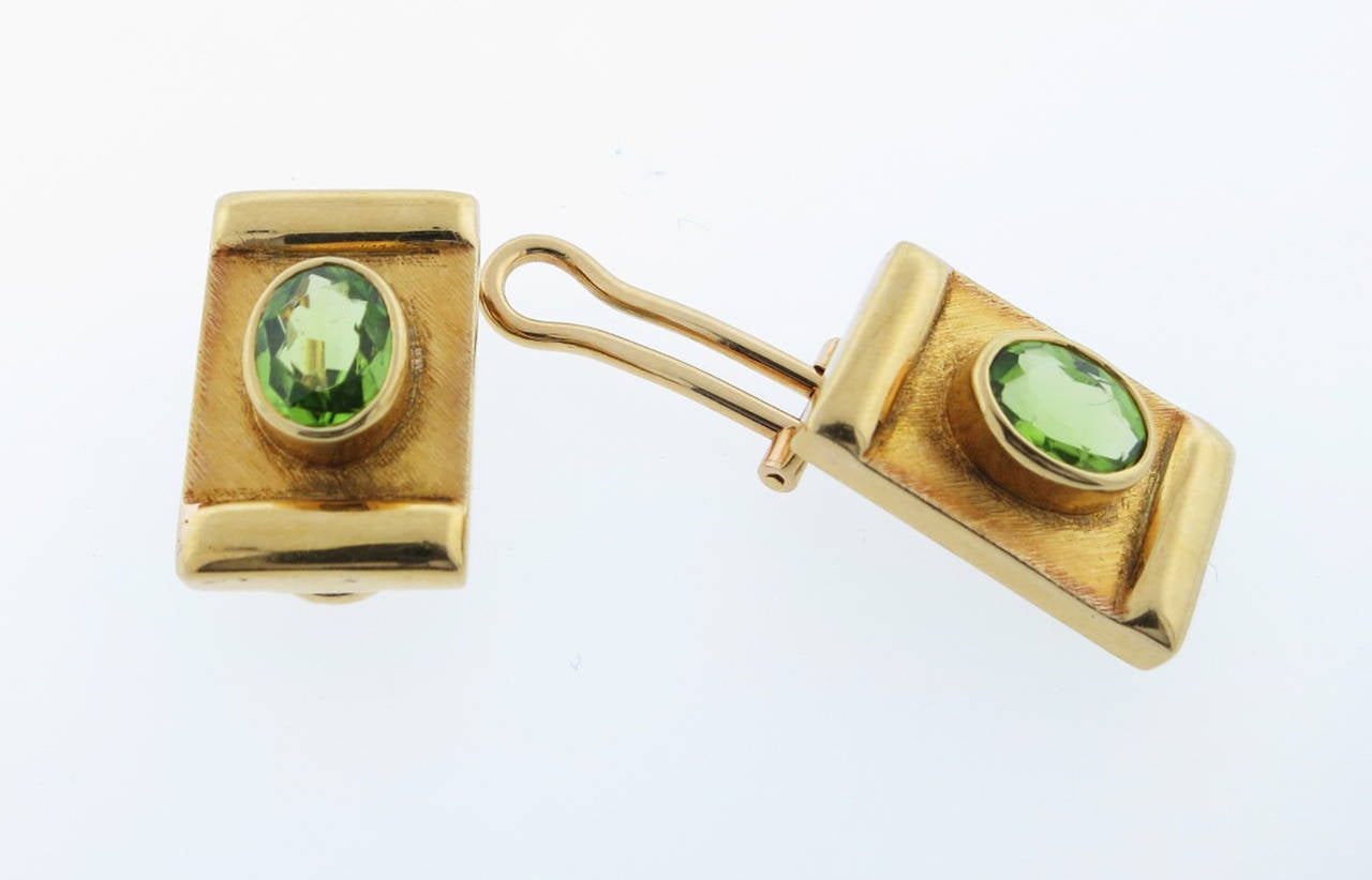 Peridot earrings made by the Brazilian jeweler Burle Marx circa 1980. The 18kt yellow gold mounts in a sand and high finish are each bezel set with an oval faceted natural peridot  weighing approx 1.1cts. Clip back posts can be added.