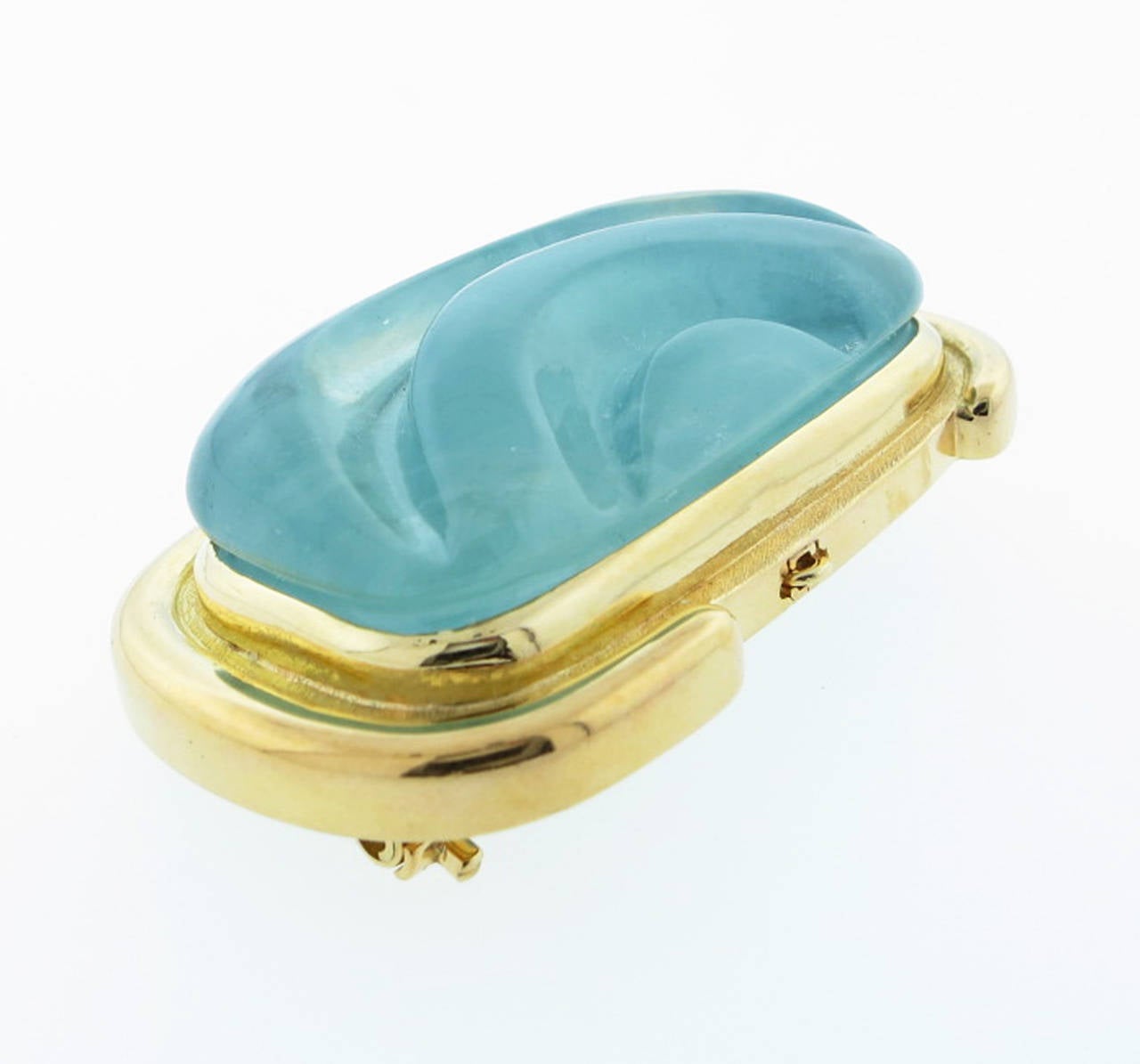 Free form carved natural aquamarine brooch -pendant in a style that made Burle Marx the modernist Brazilian jeweler famous.. The handmade 18kt. yellow gold mount has a double clip back with a retractable pendant bail. 
The aqua measures approx 1