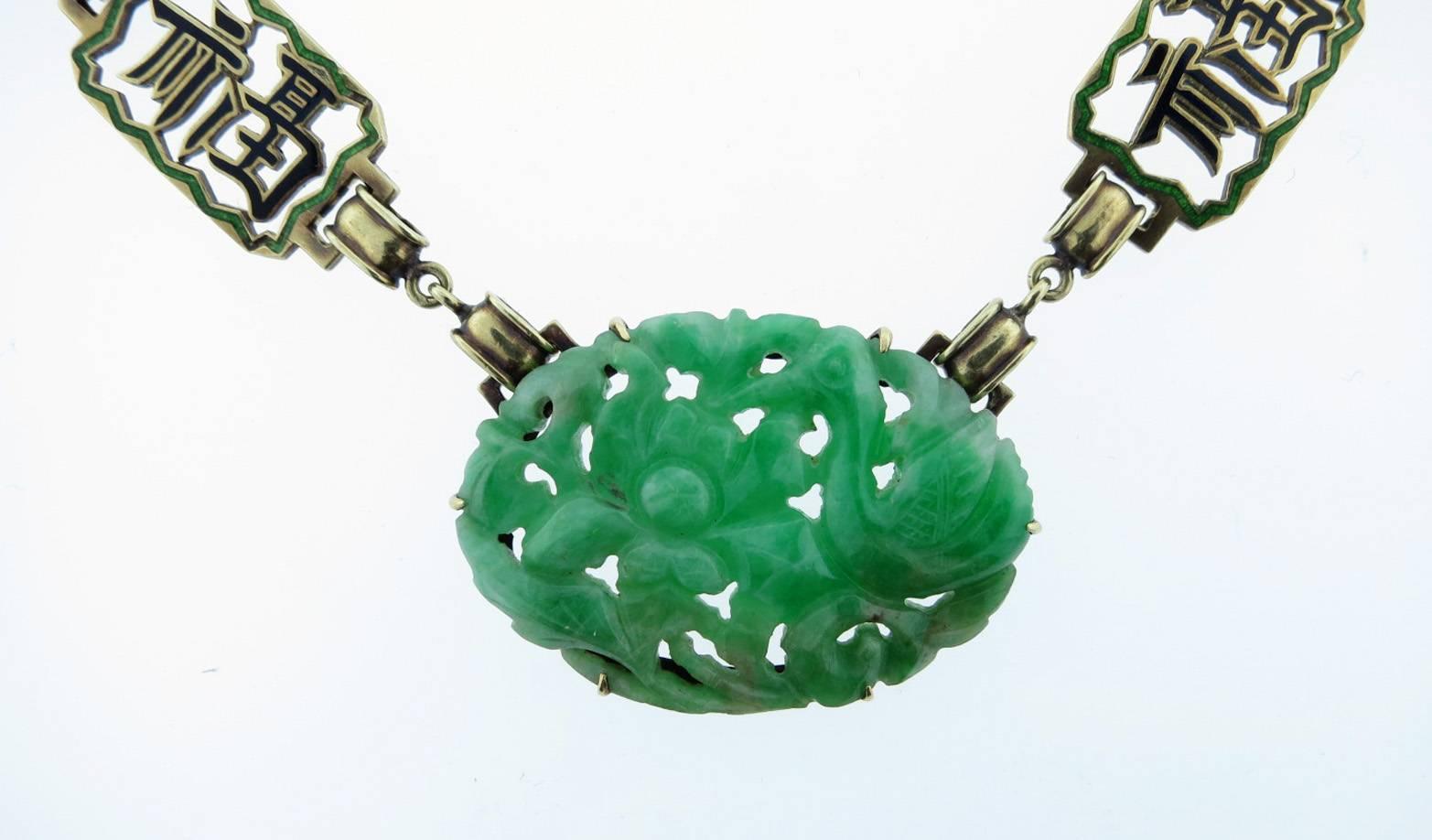14kt. yellow gold link jade plaque necklace. The carved center plaque measures approx 1 1/4 inches and is carved with flowers and bird motif. The four marquise shape carved jade disks are alternated with eight light green and black enamel open work