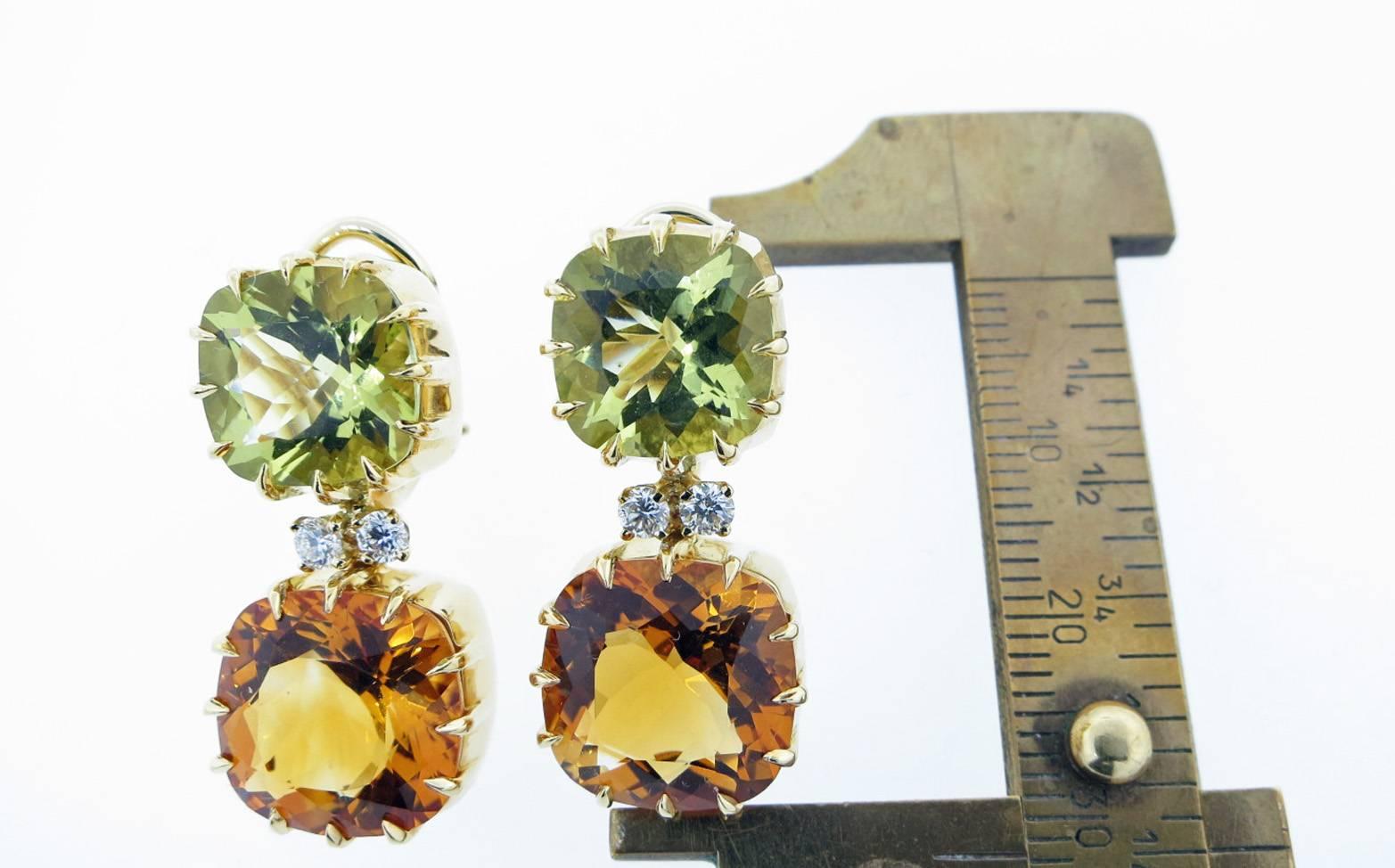 18kt. yellow gold dangle earrings by Seaman Schepps. Each earring is set with a cushion cut faceted lemon citrine measuring approx 10. mm. x 6.2 mm. each weighing approx 3.0cts.  Prong set with two round brilliant cut diamonds each weighing approx