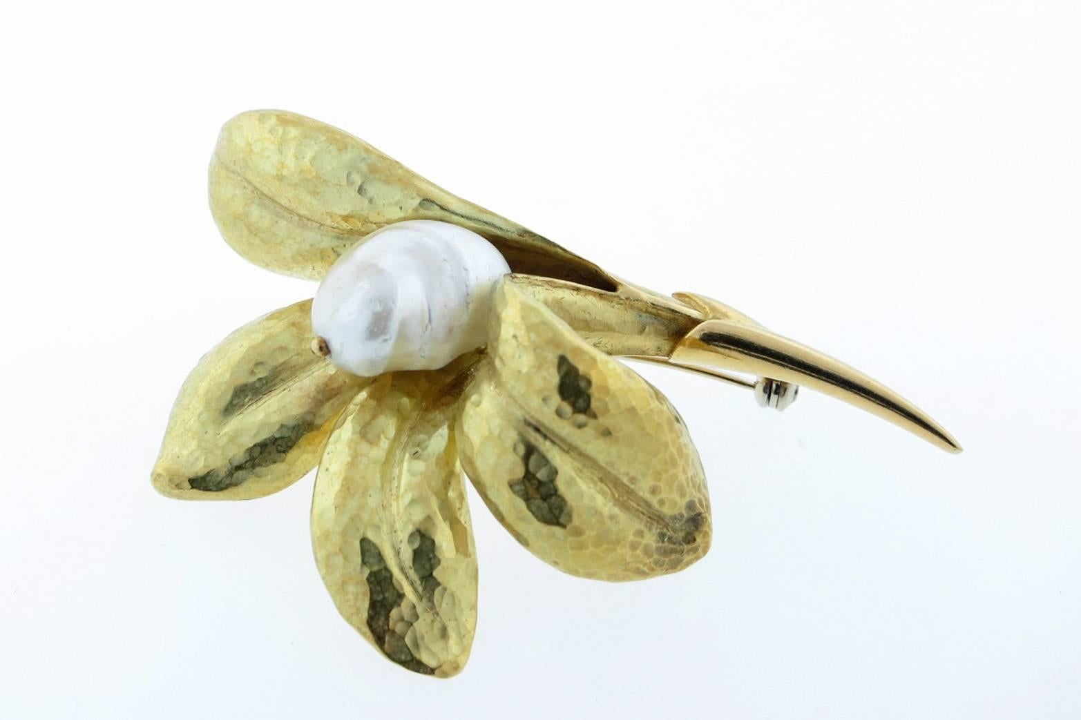 Lovely 18 kt yellow gold hammered finish flower brooch. The center is set with a lustrous baroque south sea pearl measuring approx 15 mm. The brooch measures 2.60 inches in length. Made in Italy. 