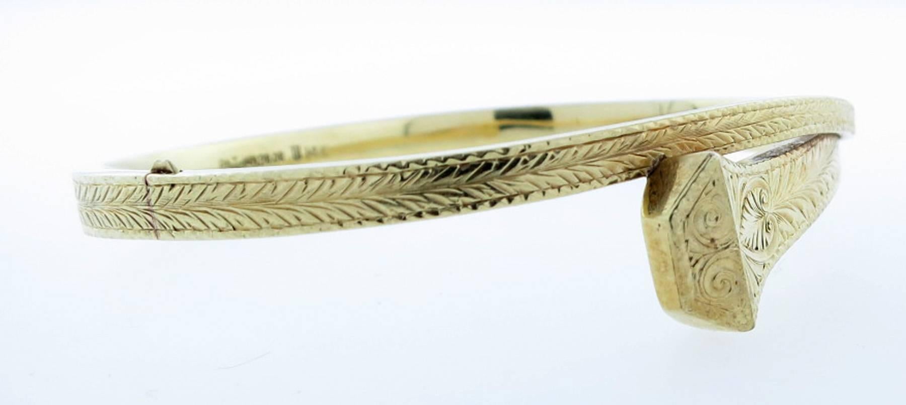 14kt. yellow gold bangle bracelet in a wrap around nail design. The bangle is hand engraved with a slide safety. The bangle will fit most wrists. Circa 1908 made by L. Fritschze & Company. 