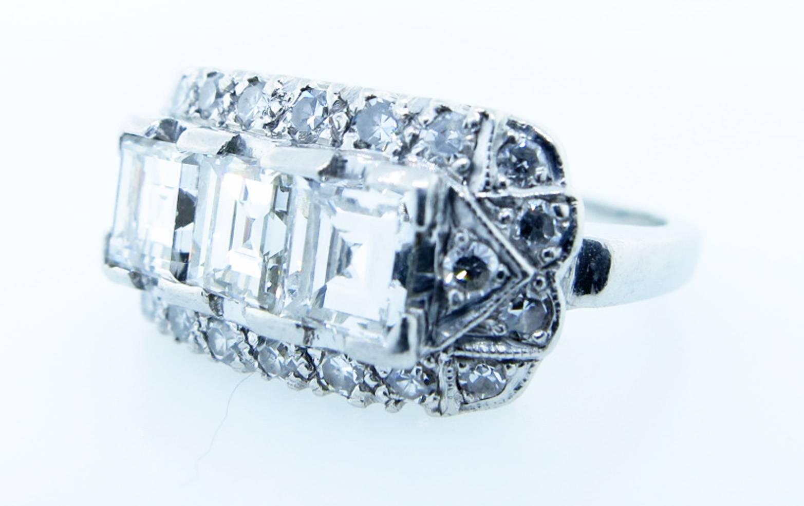 Fine quality handmade platinum mount  prong set in the center with three beautifully matched emerald cut diamonds each weighing approx .40cts. grading VS clarity H-I color. The surrounding mount is bead set with 22 round diamonds totaling approx