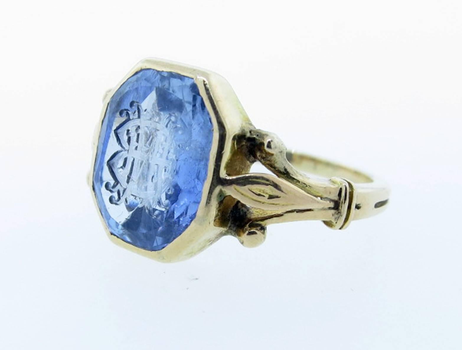 Unique antique octagonal faceted and carved natural ceylon sapphire signet ring. The sapphire weighs approx 5.0 cts. and is carved with initials which are open to interpretation. The mount is 14kt. yellow gold with pink gold accents. Size 7 1/2 and