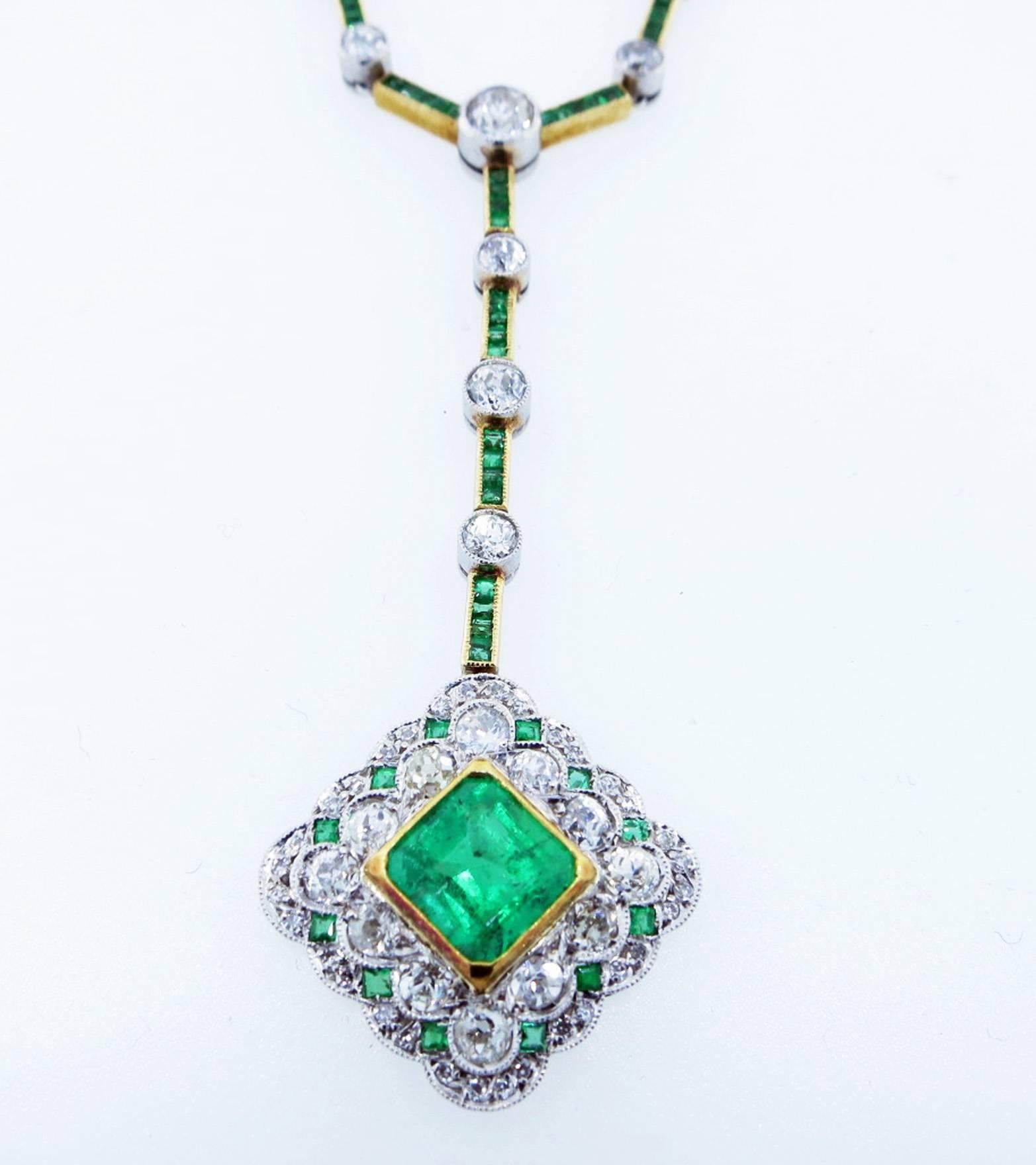 Beautiful antique natural emerald drop necklace circa 1910. The center is bezel set in 18kt. yellow gold with an emerald cut emerald weighing approx 1.25cts. intricately surrounded in a scalloped design mount with mill-grained bead set old European