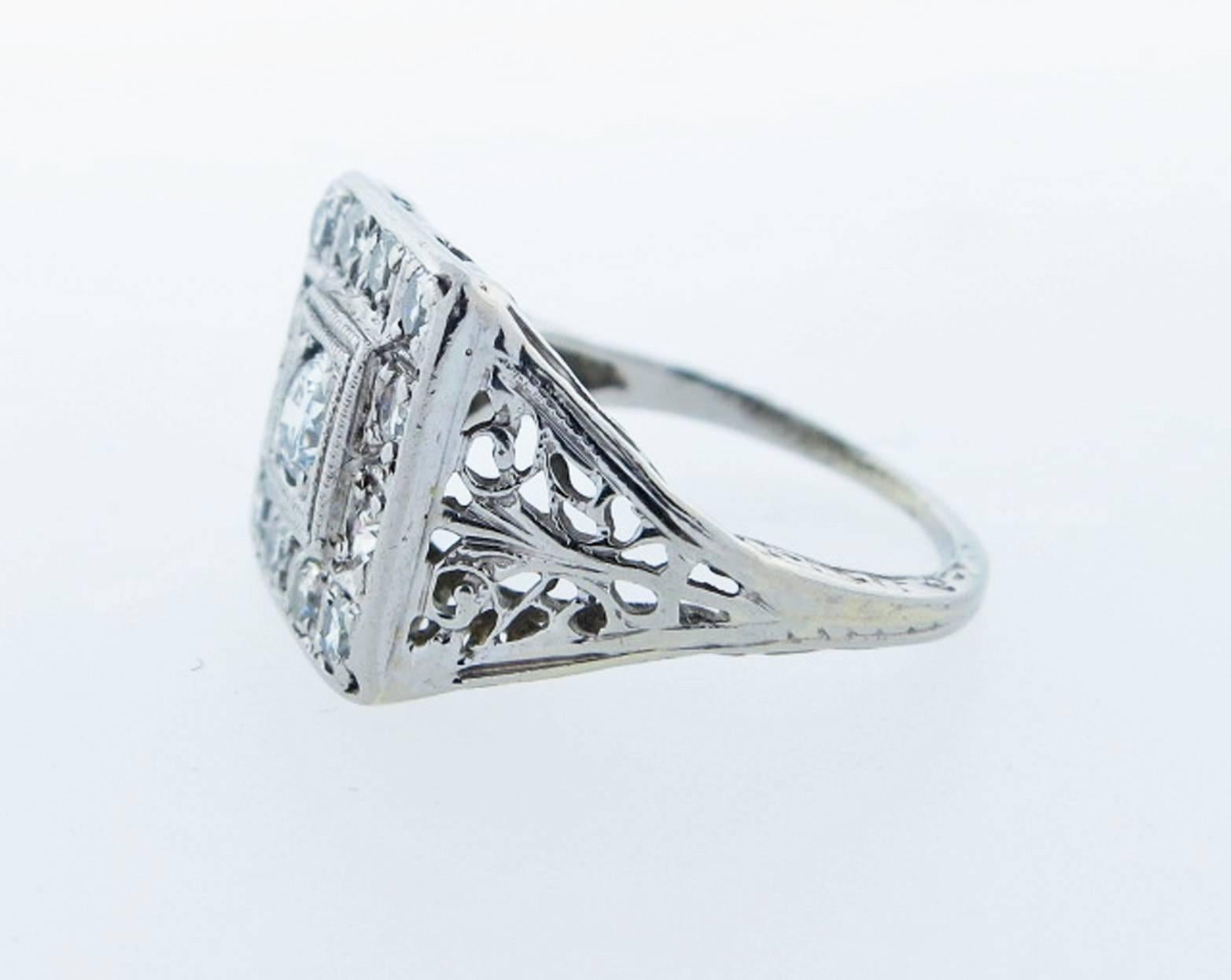 Lovely detail 18kt. white gold ring set with a center round European cut diamond weighing approx .15cts surrounded with twelve single cut diamonds totaling .25cts. Size 4 and can be sized circa 1920.