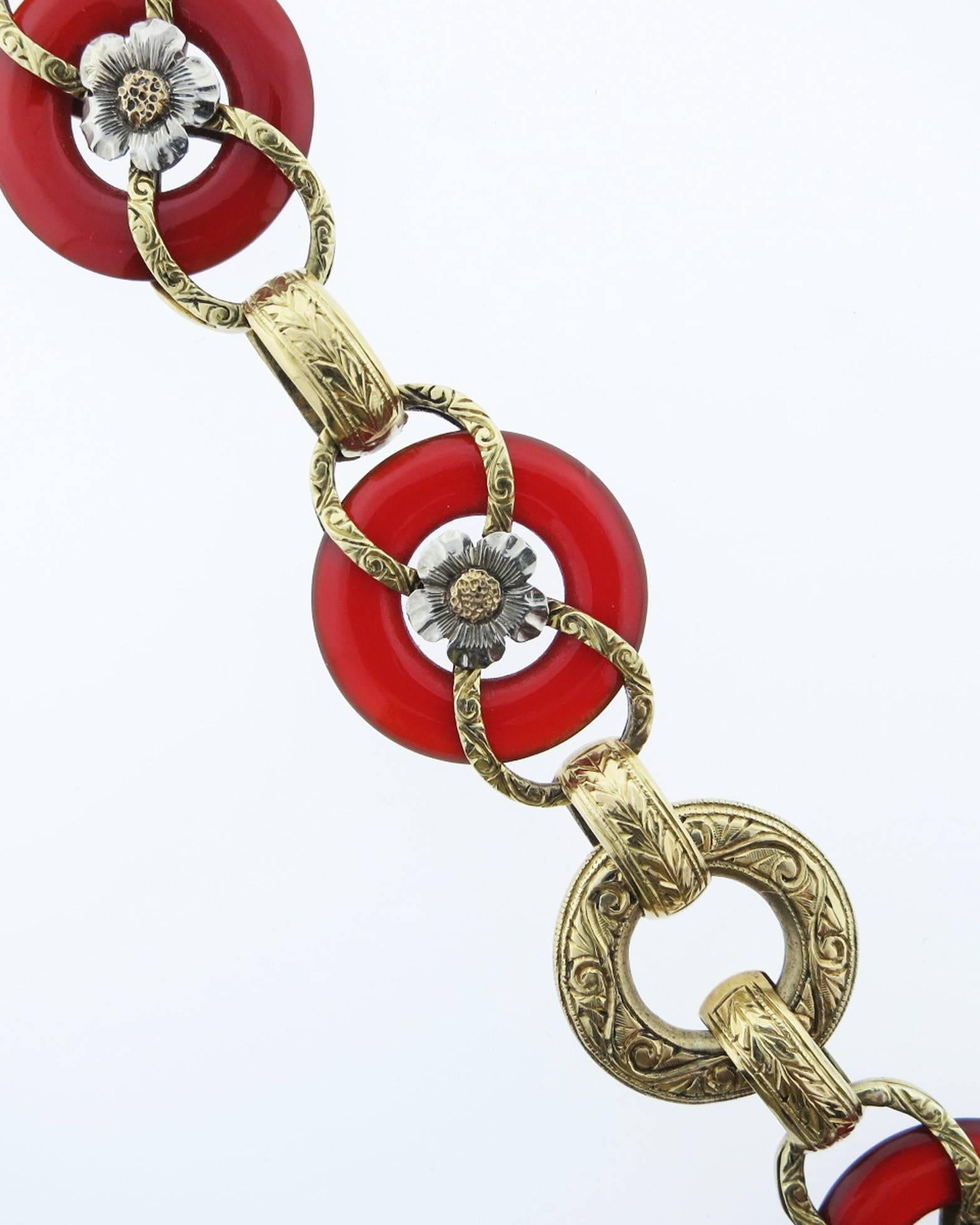 Beautifully made and heavily engraved 14kt. yellow gold bracelet consisting of four open carnelian rings inset with white gold flower centers and four connecting gold links.The bracelet measures 7 3/4 inches of length. Circa 1900. 
Excellent